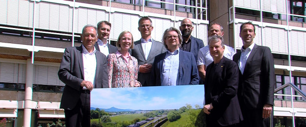 Die Projektbeteiligten halten vor dem Landratsamt ein Bild der Zollern-Alb-Bahn hoch (Quelle: RIK)